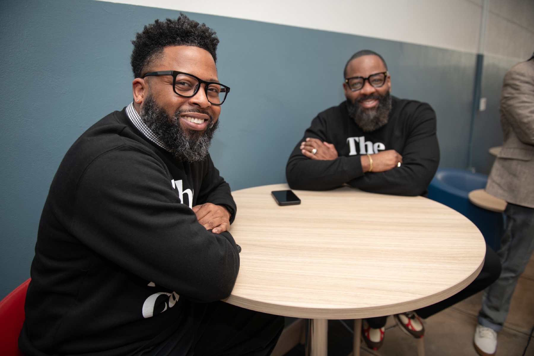 Two Black male educators smiling at a round table